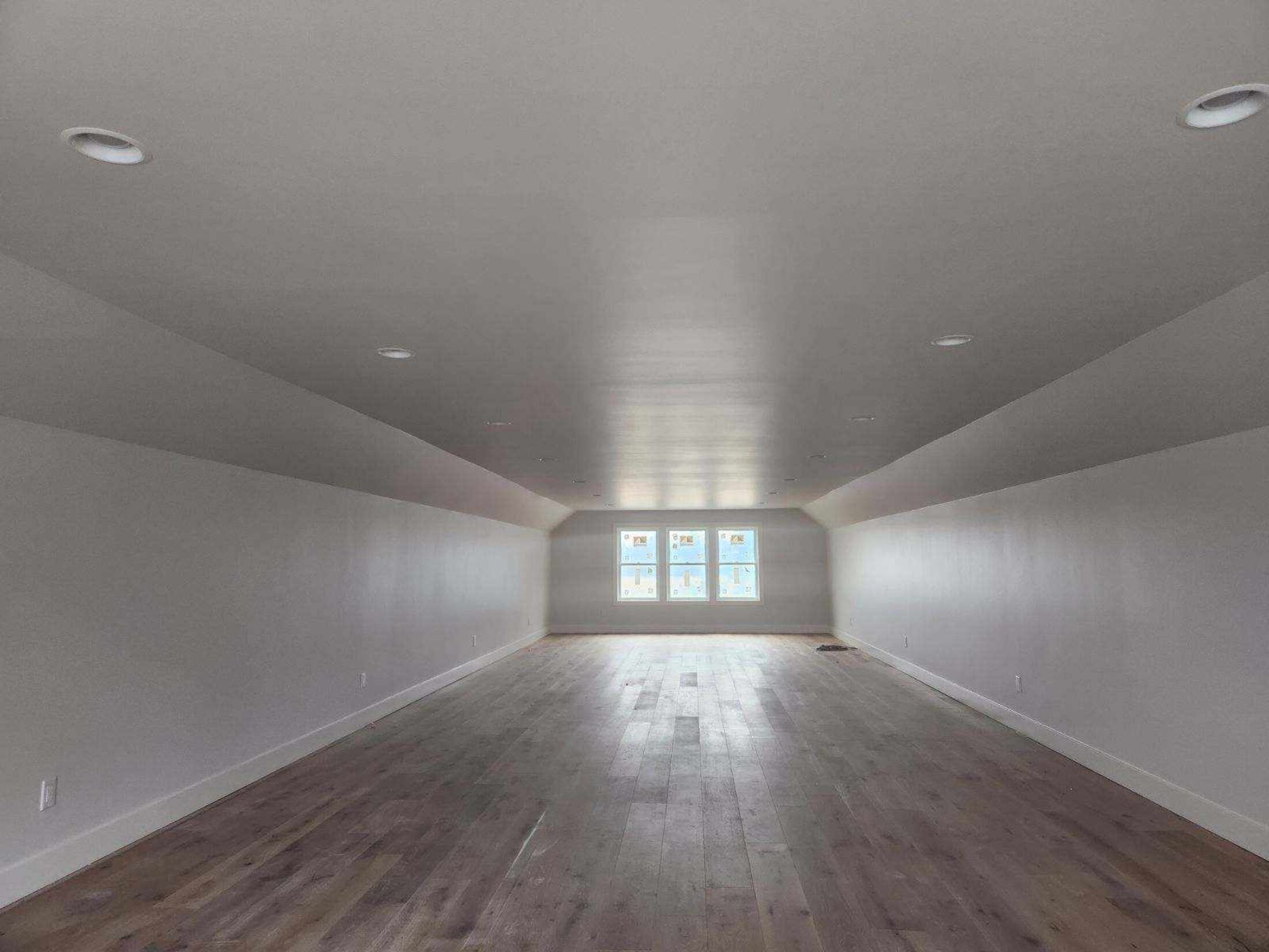A finished room with daylight raking across the walls and floor